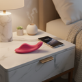 App-controlled wearable wellness device in soft pink resting on a table for independent use.