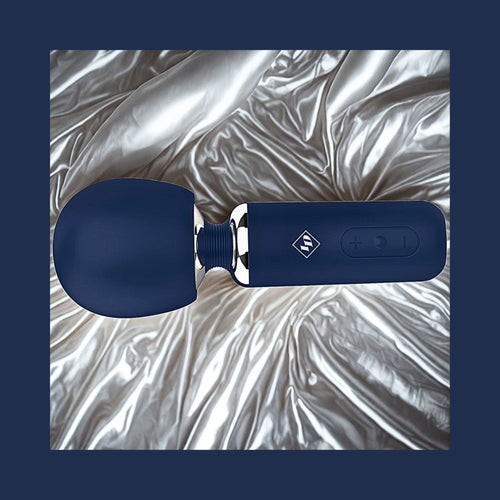 Give Into Me Wellness Wand for Flexible Percussive Care, shown on a luxury bedspread, highlighting its Ergonomic Stability Grip and flexible neck.