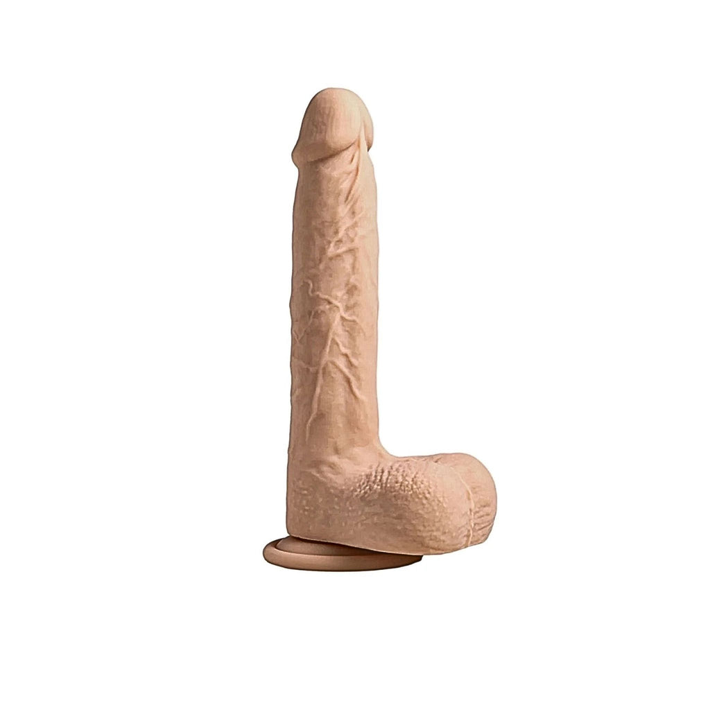 Heated adaptive sensory massager in soft beige displayed with a secure hands-free base.