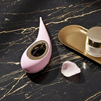 Lelo Dot in pink for limited mobility displayed on black marble and gold accents.