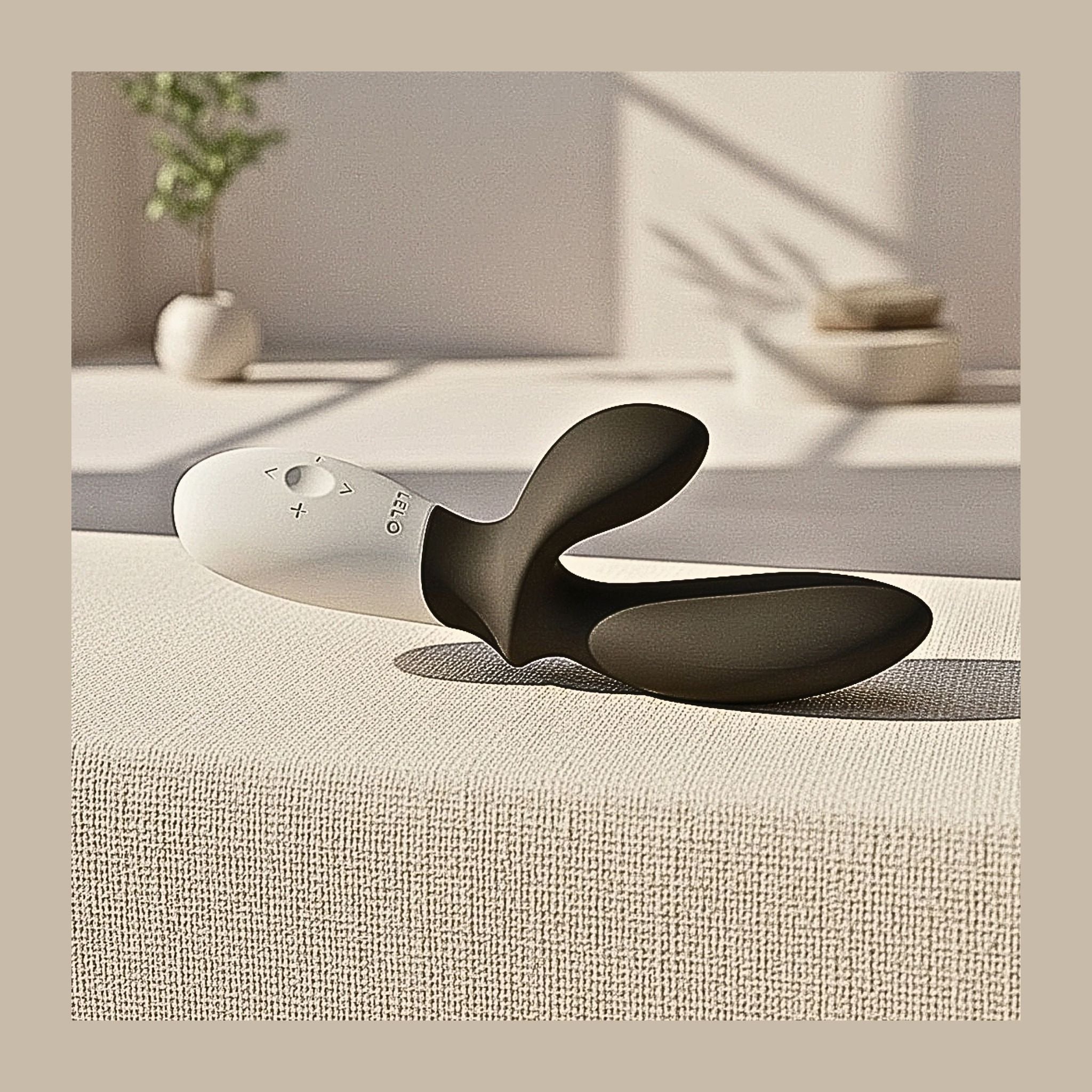 Lelo Loki Wave massager on textured surface with an easy-to-grip, ergonomic handle for thumb and wrist joint ease.
