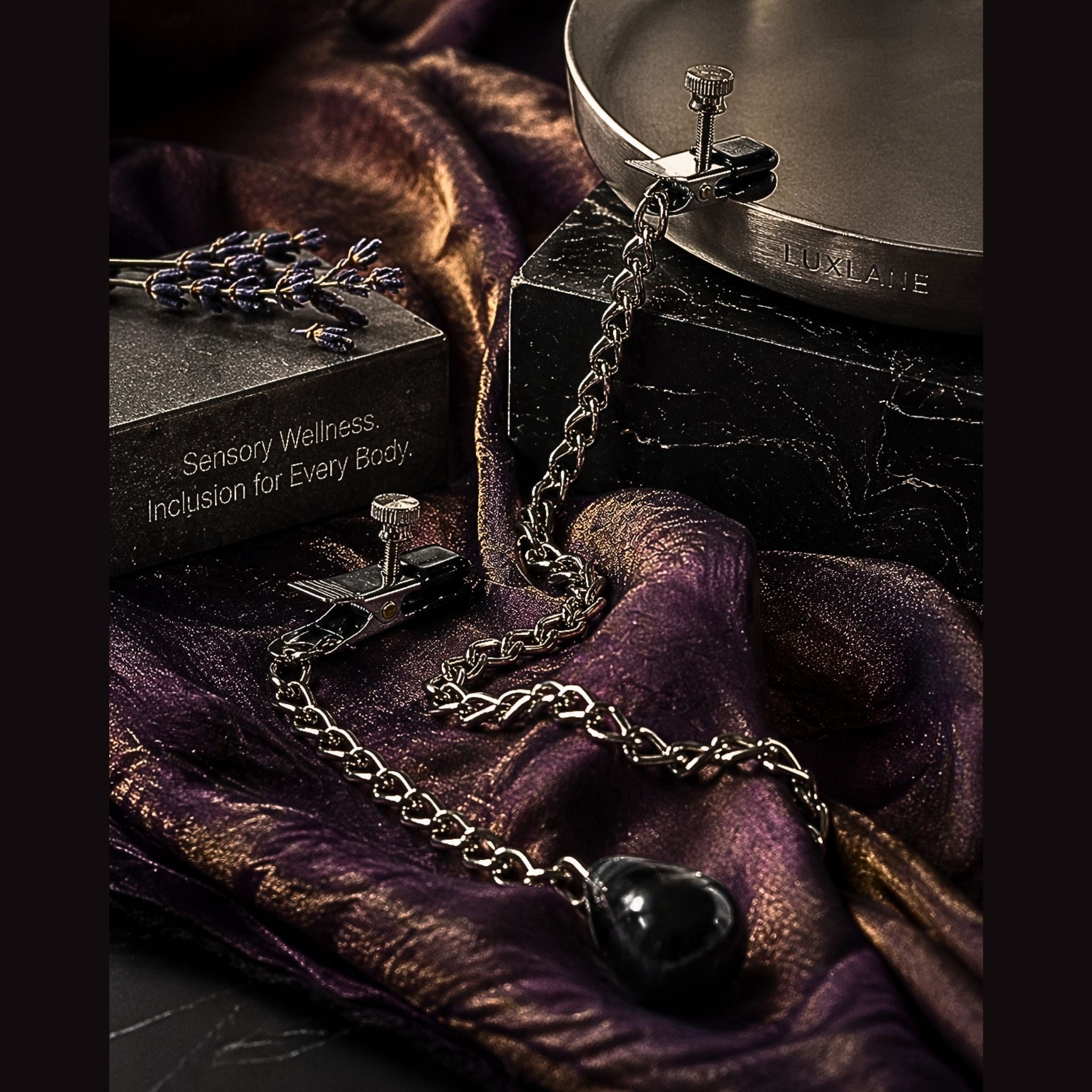 Weighted sensory clamps draped over silk and marble, featuring a 4.5 oz teardrop weight for gravity-assisted tactile feedback.