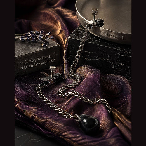 Weighted sensory clamps draped over silk and marble, featuring a 4.5 oz teardrop weight for gravity-assisted tactile feedback.